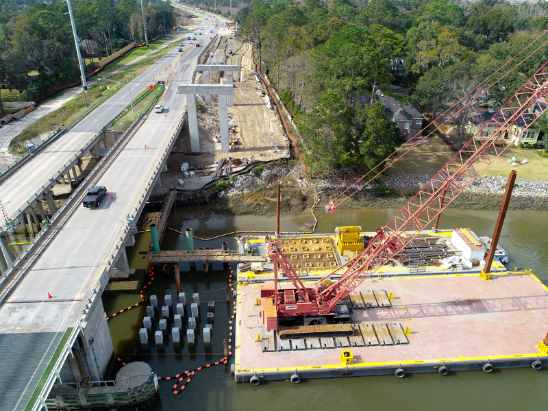 Aerial view of a bridge under construction with a crane in the river